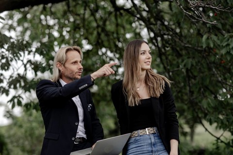 Man and woman talking on a wooden table in nature