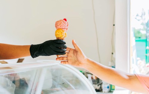 Close-up of hands buying an ice cream. Close up of hands receiving an ice cream cone. Close up of person buying an ice cream cone