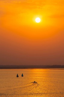 Yacht boats silhouettes in lake on sunset