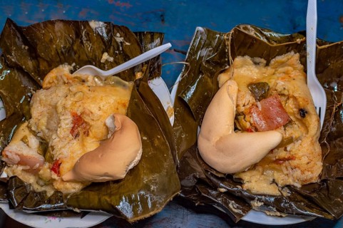 Two Nacatamales served in a banana leaf on the table. Top view of two traditional Nacatamales served on banana leaf