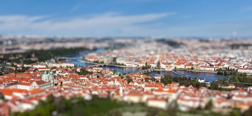Aerial view of Charles Bridge over Vltava river and Old city from Petrin hill Observation Tower with tilt shift toy effect shallow depth of field. Prague