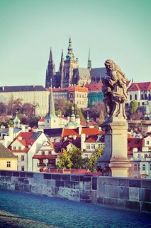 Vintage retro hipster style travel image of statue on Charles Brigde with St. Vitus Cathedral in background in Prague