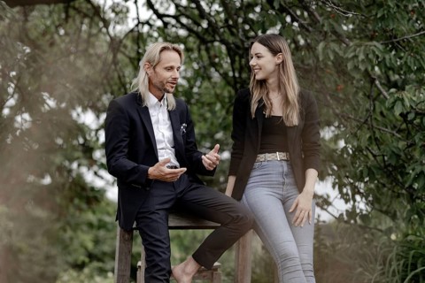Man and woman talking on a wooden table in nature