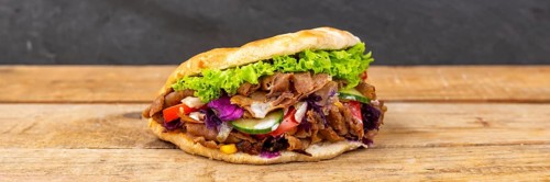 Doener Kebab Doner Kebap fast food in pita bread on wooden board Panorama in Stuttgart