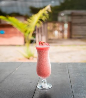 Close up of healthy strawberry smoothie on wood with blurred background