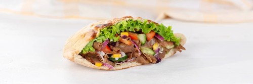 Doener Kebab Doner Kebap half fast food meal in pita bread on wooden board Panorama in Stuttgart