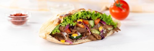 Doener Kebab Doner Kebap fast food in pita bread on wooden board Panorama in Stuttgart