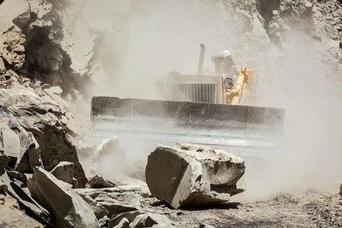 Bulldozer cleaning landslide from road in Himalayas. Himachal Pradesh