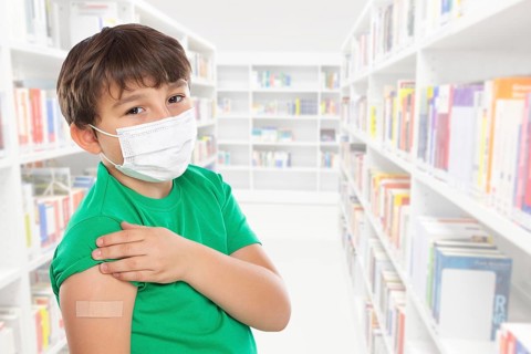 Child boy with plaster at children vaccination in school mask against coronavirus corona virus text free space copyspace in Stuttgart
