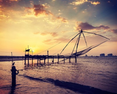 Vintage retro hipster style travel image of Kochi chinese fishnets on sunset. Fort Kochin