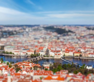 Aerial view of Charles Bridge over Vltava river and Old city from Petrin hill Observation Tower with tilt shift toy effect shallow depth of field. Prague