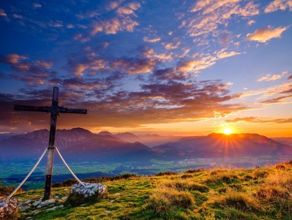 Summit cross of the Schlenken at sunset clouds