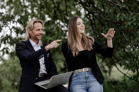 Man and woman talking on a wooden table in nature