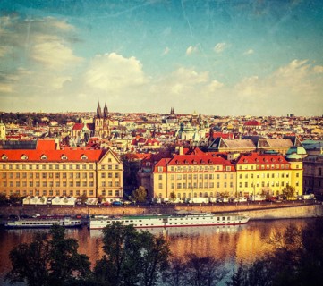 Vintage retro hipster style travel image of aerial view of Prague and Vltava river on sunset
