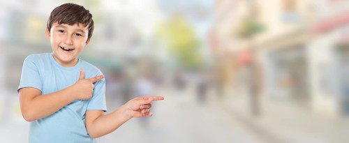 Child boy pointing finger at advertisement in the city with copy space Copyspace in Stuttgart
