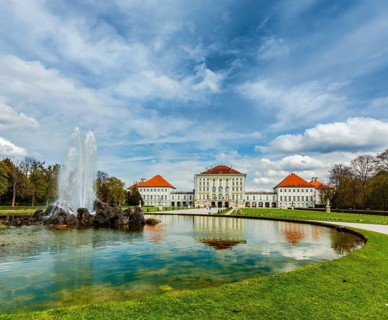 Fountain in Grand Parterre Baroque garden and the rear view of the Nymphenburg Palace. Munich