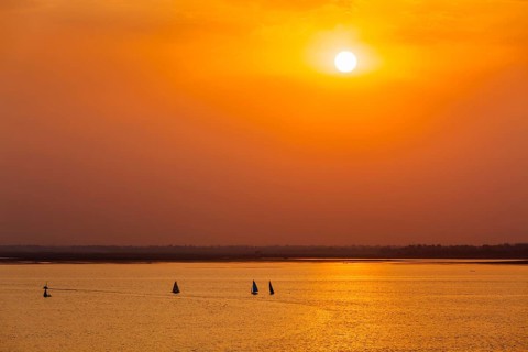 Yacht boats silhouettes in lake on sunset