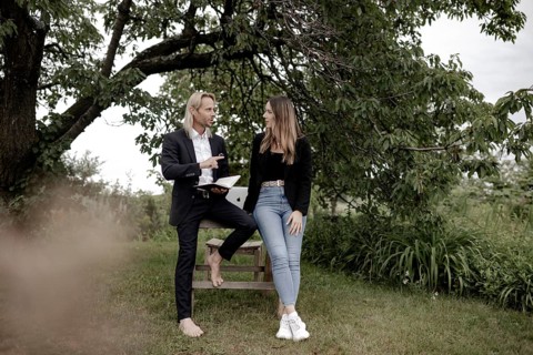 Man and woman talking on a wooden table in nature
