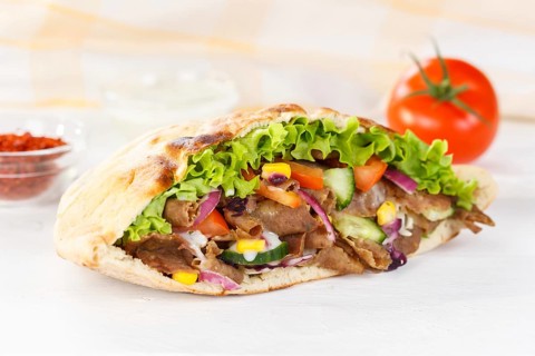 Doener Kebab Doner Kebap fast food meal in pita bread on wooden board in Stuttgart