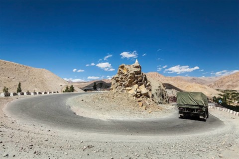 Road in Himalayas with army truck. Ladakh