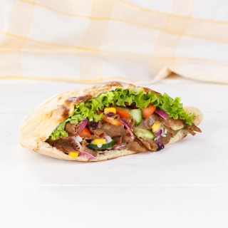 Doener Kebab Doner Kebap half fast food meal in pita bread on wooden board square in Stuttgart