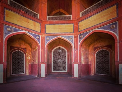 Vintage retro effect filtered hipster style travel image of arch with carved marble window. Mughal style. Humayun's tomb