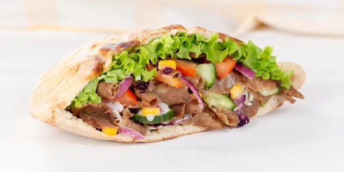 Doener Kebab Doner Kebap half fast food meal in pita bread panorama on wooden board in Stuttgart