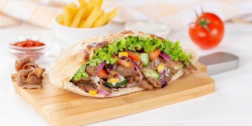 Doener Kebab Doner Kebap half fast food meal in pita bread with fries on wooden board Panorama in Stuttgart