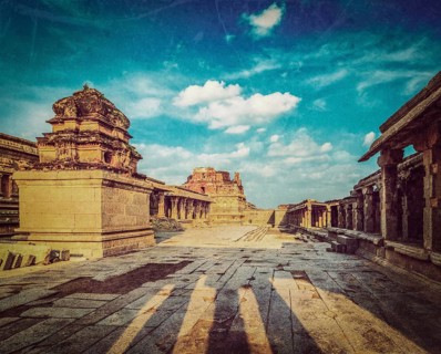 Vintage retro hipster style travel image of Krishna temple on sunset with grunge texture overlaid. Royal Center