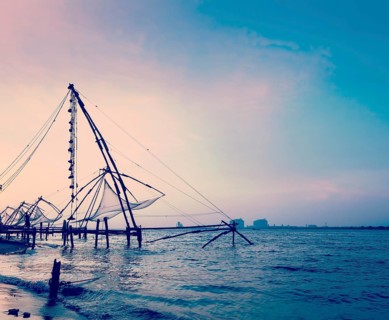 Vintage retro hipster style travel image of Kochi chinese fishnets on sunset. Fort Kochin