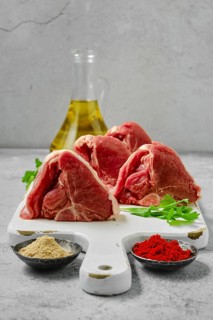 Raw boneless rack of lamb on wooden cutting board