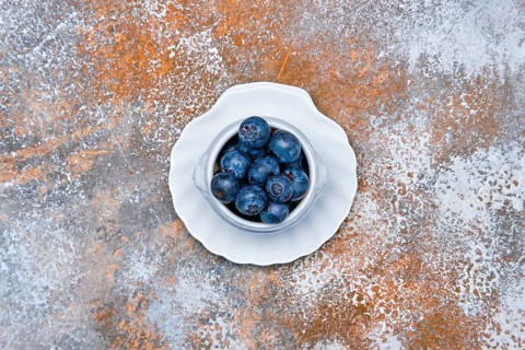 Top view of porcelain bowl with fresh blueberry