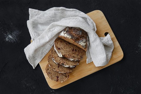Overhead view of artisan freshly baked broun bread with raisins cut on slices