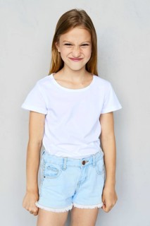 Young angry and mischievous girl in white t-shirt and jeans shorts posing in studio
