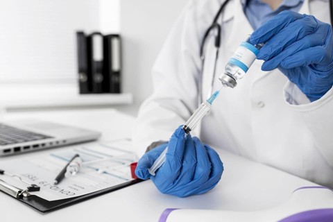 Close up doctor holding medical syringe