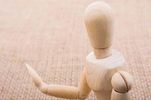 Wooden dolls of a man posing on canvas