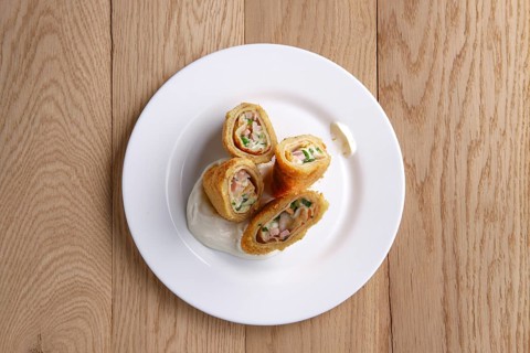 Top view of deep-fried pancakes stuffed with ham and covered with melted cheese