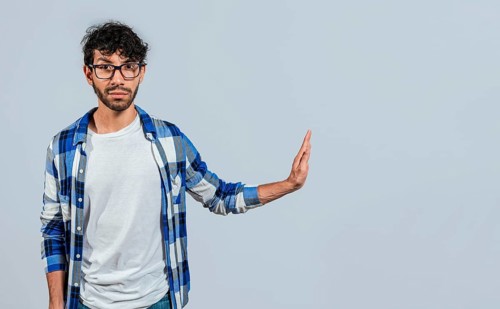 Displeased young man rejecting with rejection gesture