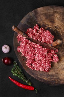 Top view of fresh beef minced meat on wooden chopping stump