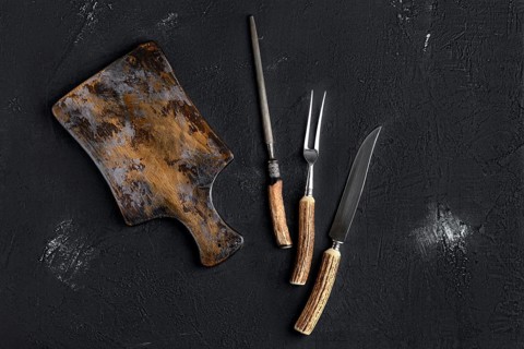 Rustic shabby cutting board with knife and fork for steak and knife sharpener