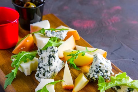 Cheese plate with honey and black and yellow olives