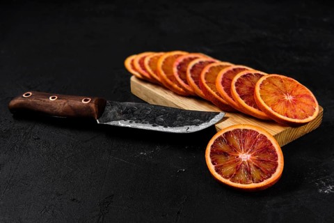Overhead view of slices of blood orange on black background