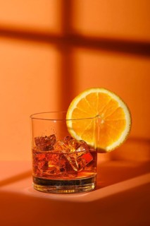 Cold cocktail with brandy and orange liquor with reflection of a window frame on background