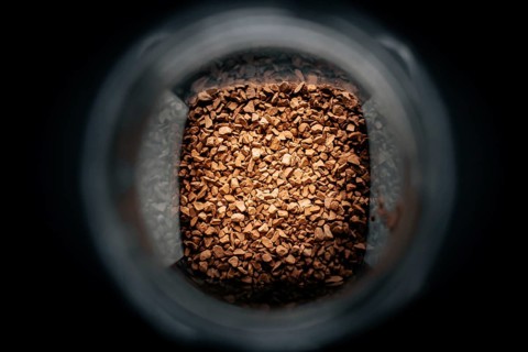 Photo of a jar with instant coffee in a dark background