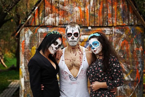 Three daemons in front of old painted barn. Face painting art