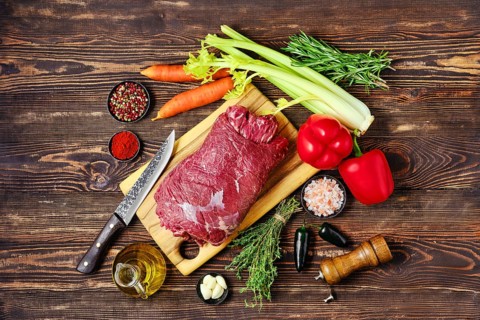 Overhead view of raw beef roll stuffed with vegetables for baking in oven