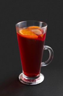 Hot cherry tea with orange and lemon on gray background