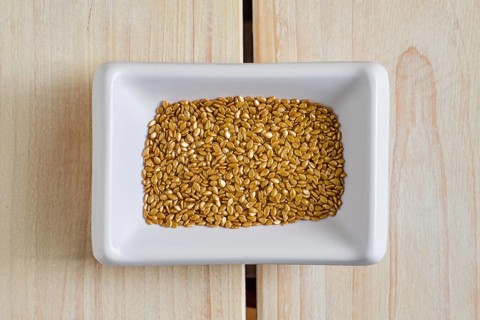 Top view of gold plated sesame seeds in cepamic bowl
