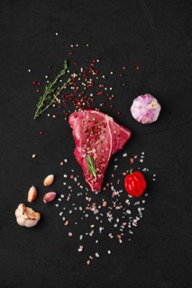 Overhead view of raw chuck eye steak with ingredients for cooking
