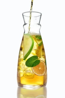 Filling up the jar with icy apple and orange drink with mint flavour